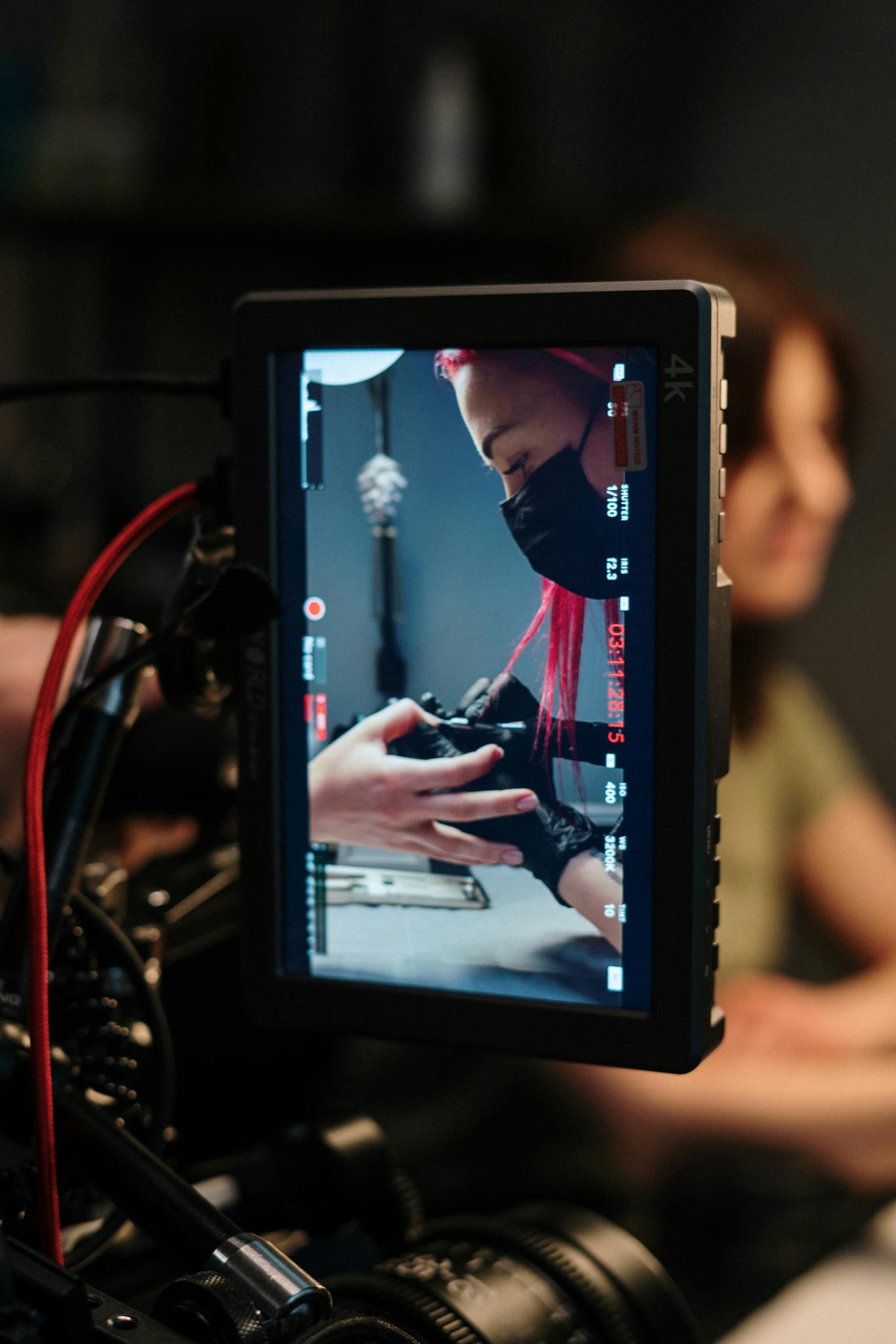 A camera captures a nail artist working in a salon, highlighting professional beauty setup.