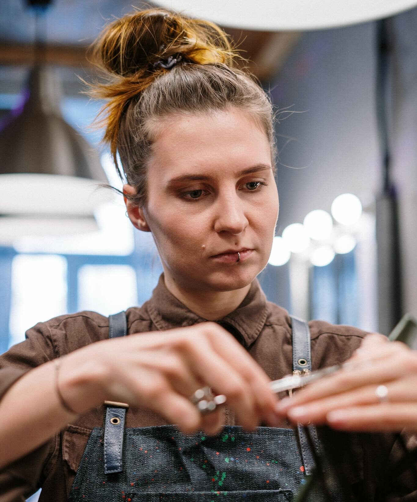 A focused female hairdresser skillfully cutting hair in a contemporary salon setting.